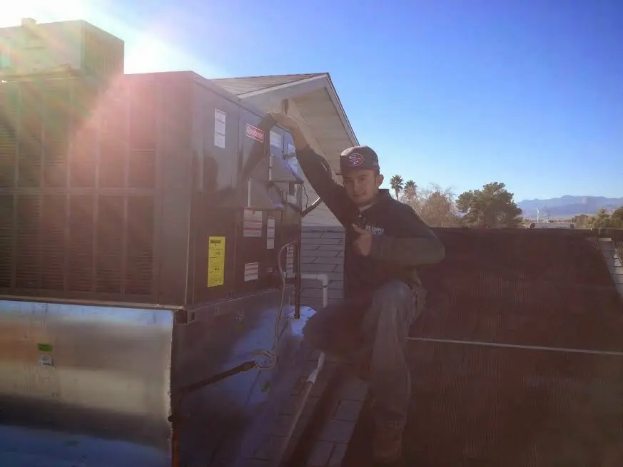 HVAC technician performing AC Tune-Up on a rooftop unit in Orrville